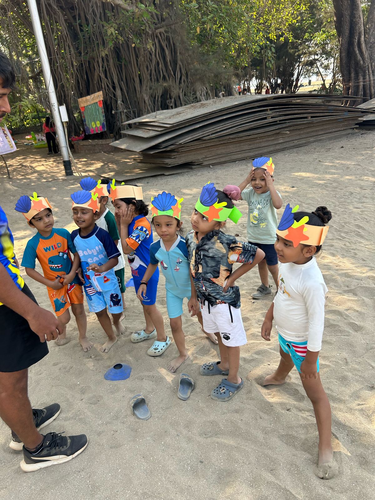 Children in sea-themed crowns on the sand