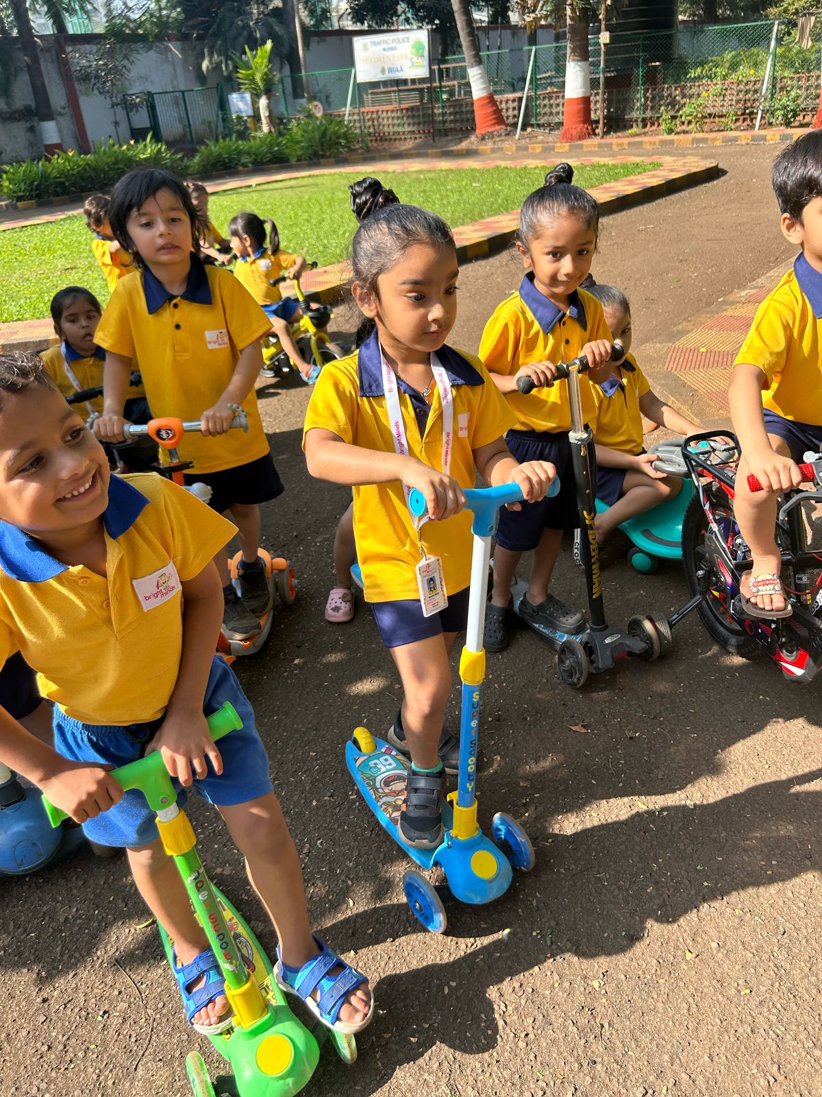Children in uniform riding scooters at a traffic safety park